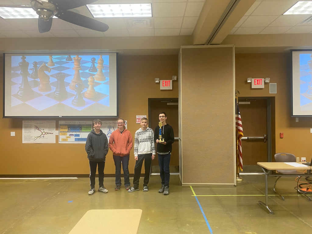 omaha students stand with their chess trophy
